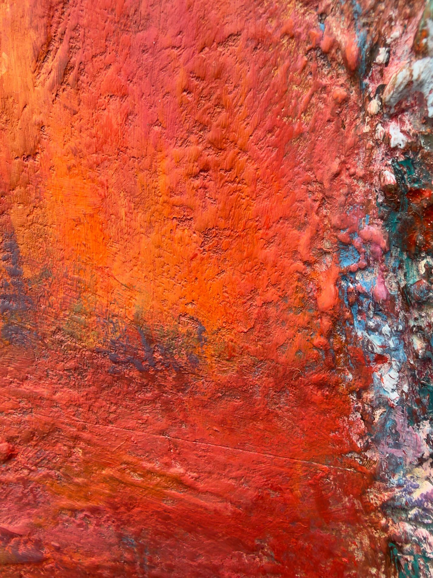 Close-up of layered red and orange plaster and paint beside the figure in After the Fire