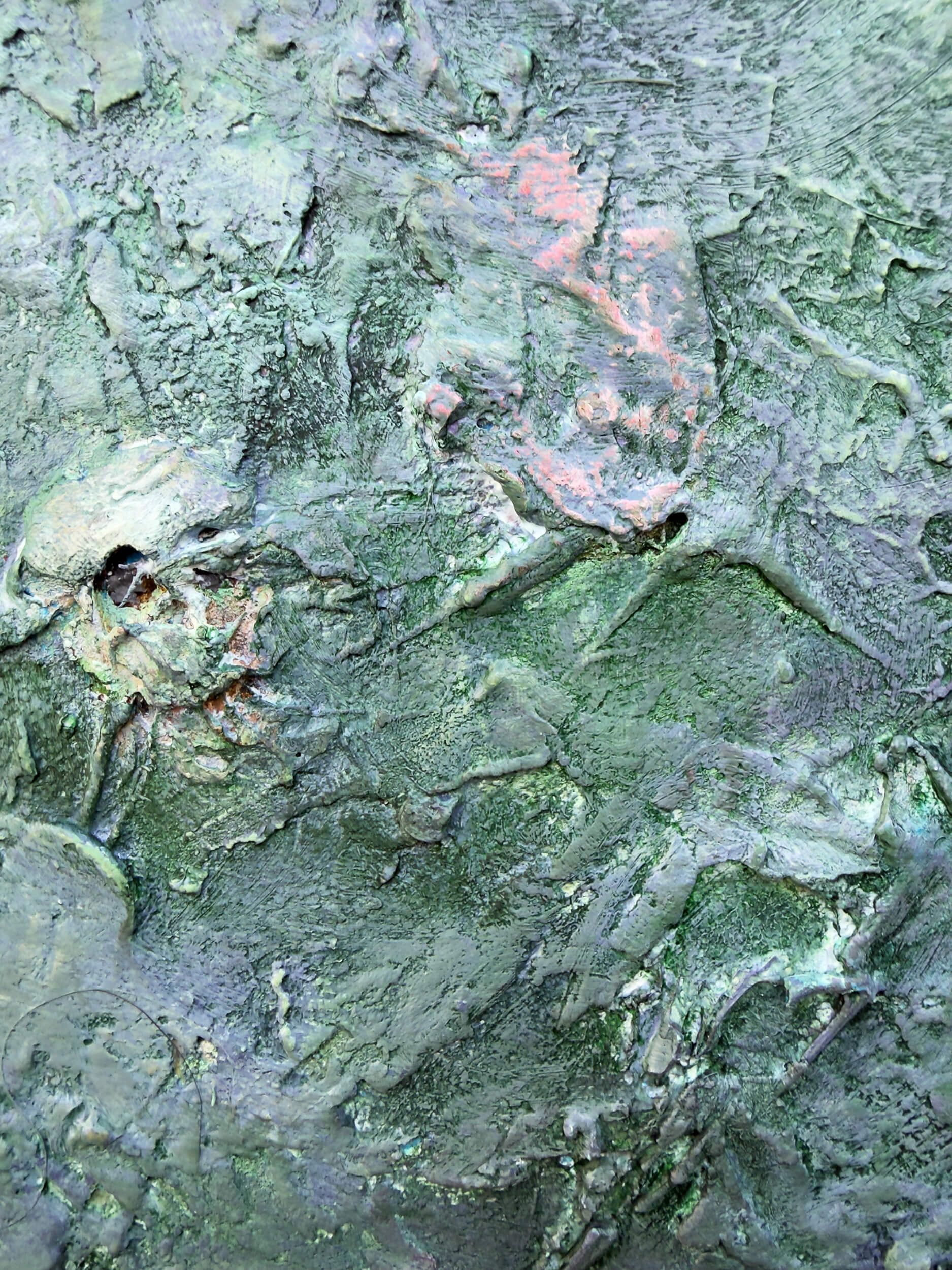 Concealed skull-like form within layers of green plaster and paint in Relic of the Divided Self