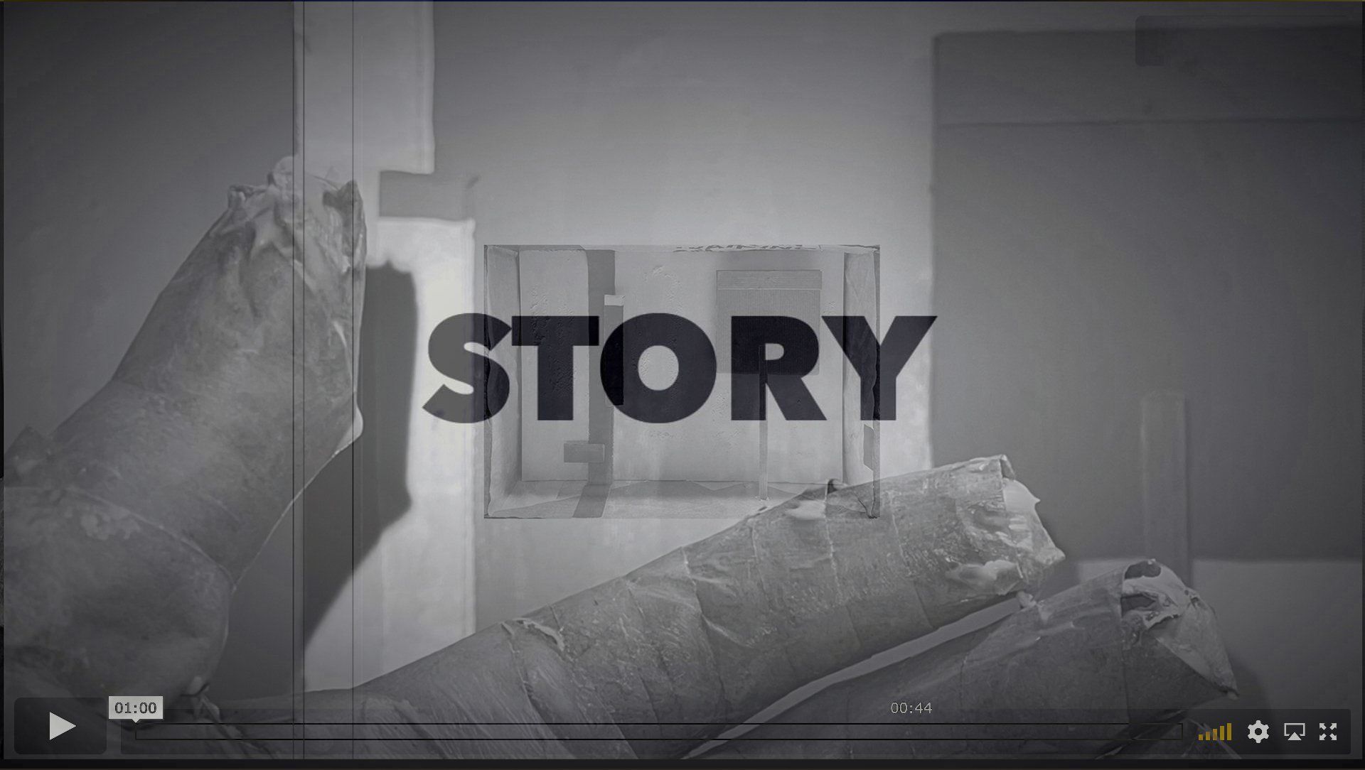 Still from Story showing a grayscale interior with a sleeping bag against a wall and the word “STORY” overlaid in bold text