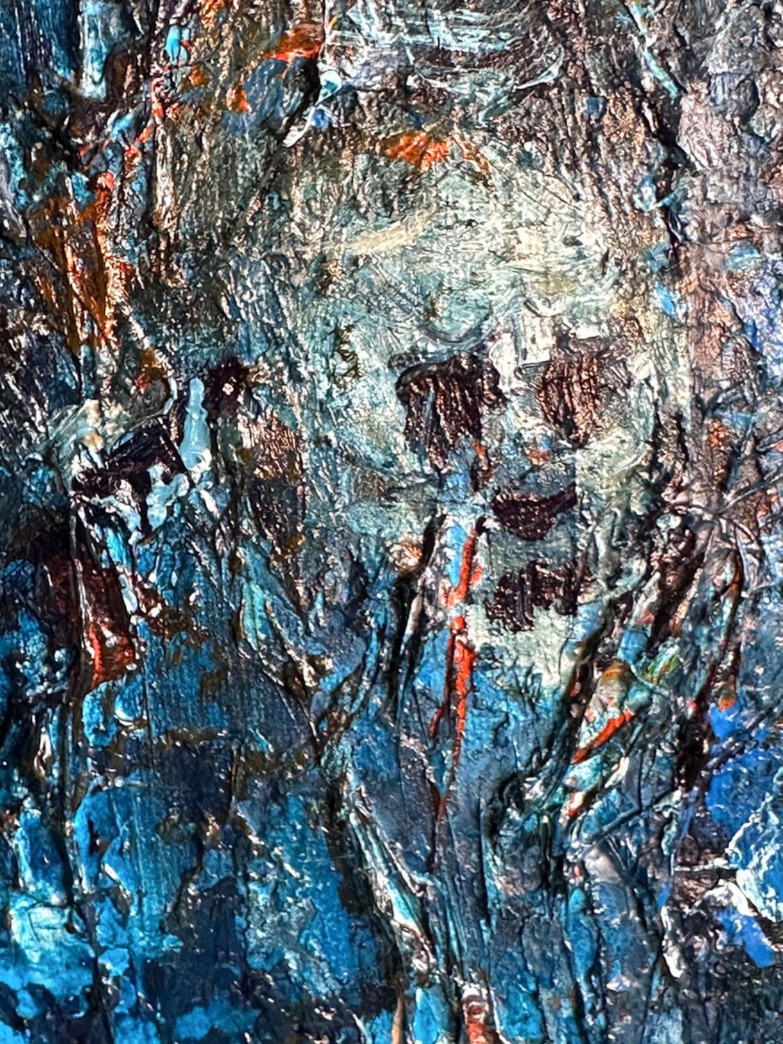 Close-up of The Ancestors showing a pale fragmented skull surrounded by dark blue paint, embedded fragments and fine red-orange marks.