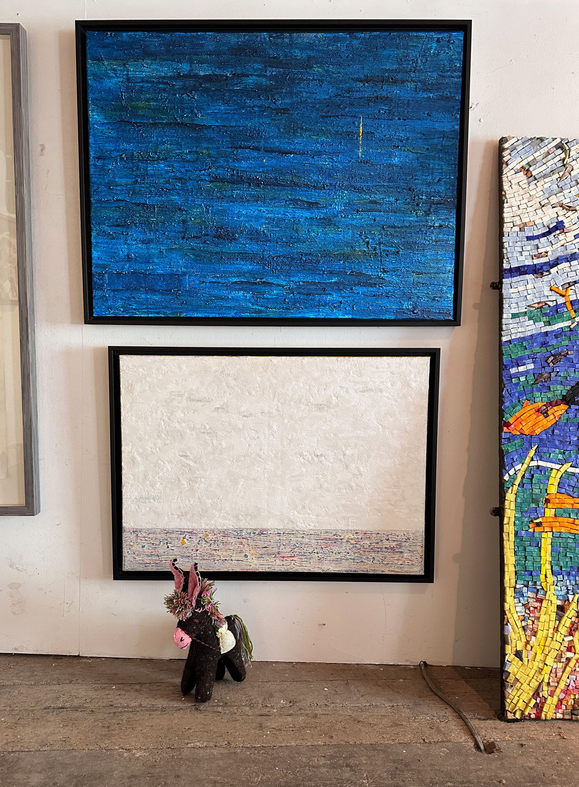 Abstract Paintings at the gallery. The mascot a small toy mule stands in front.