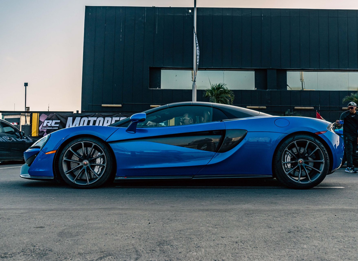 Blue sports car parked outdoors in front of a building