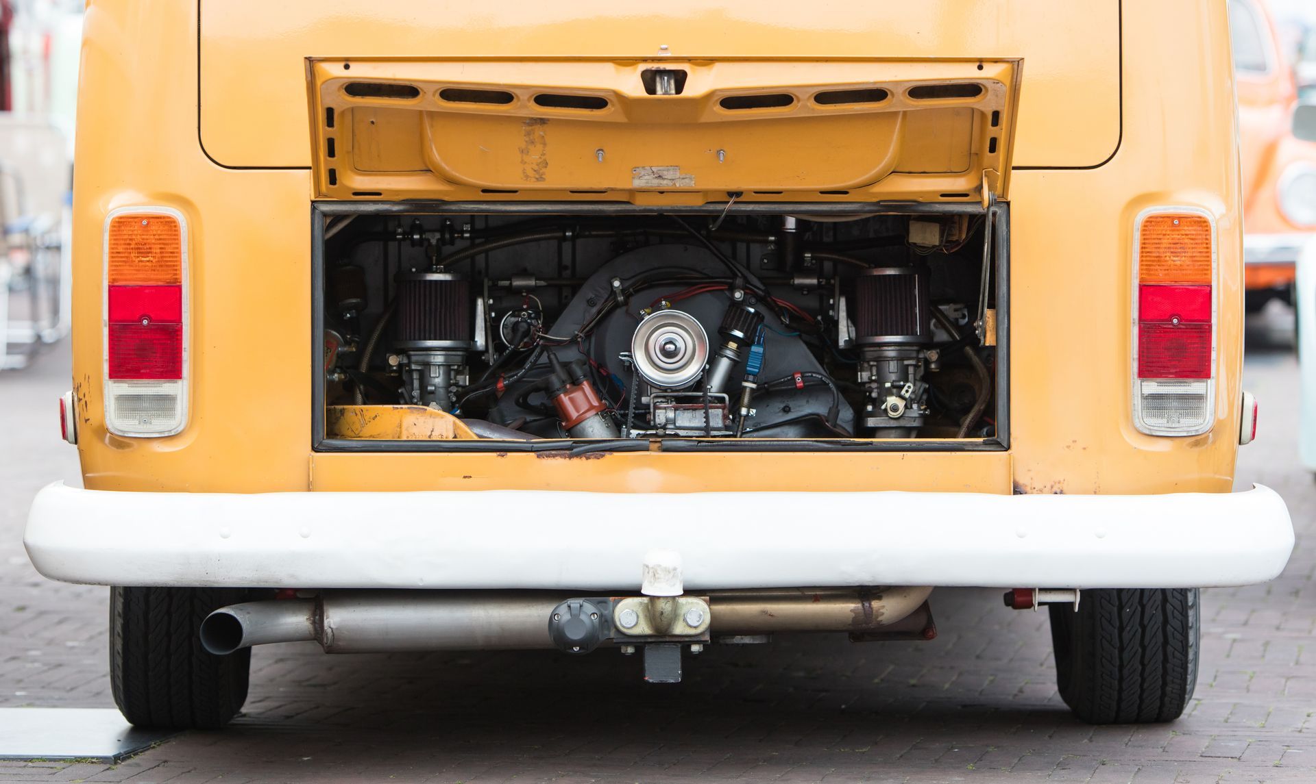 Rear view of a classic van with rear hatch open, exposing the engine compartment.