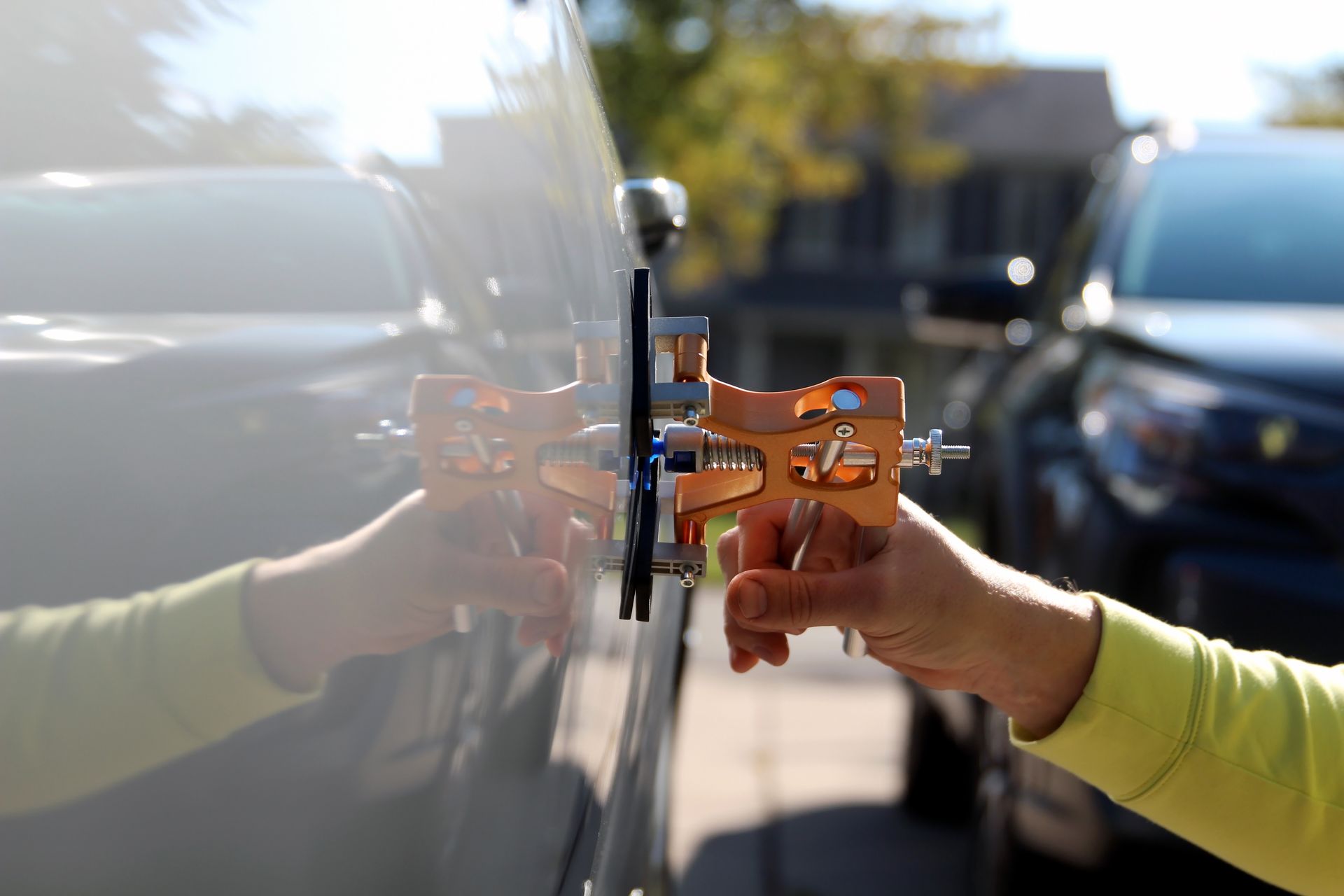 Hands using a car door lock with a keyless entry device in a parking lot