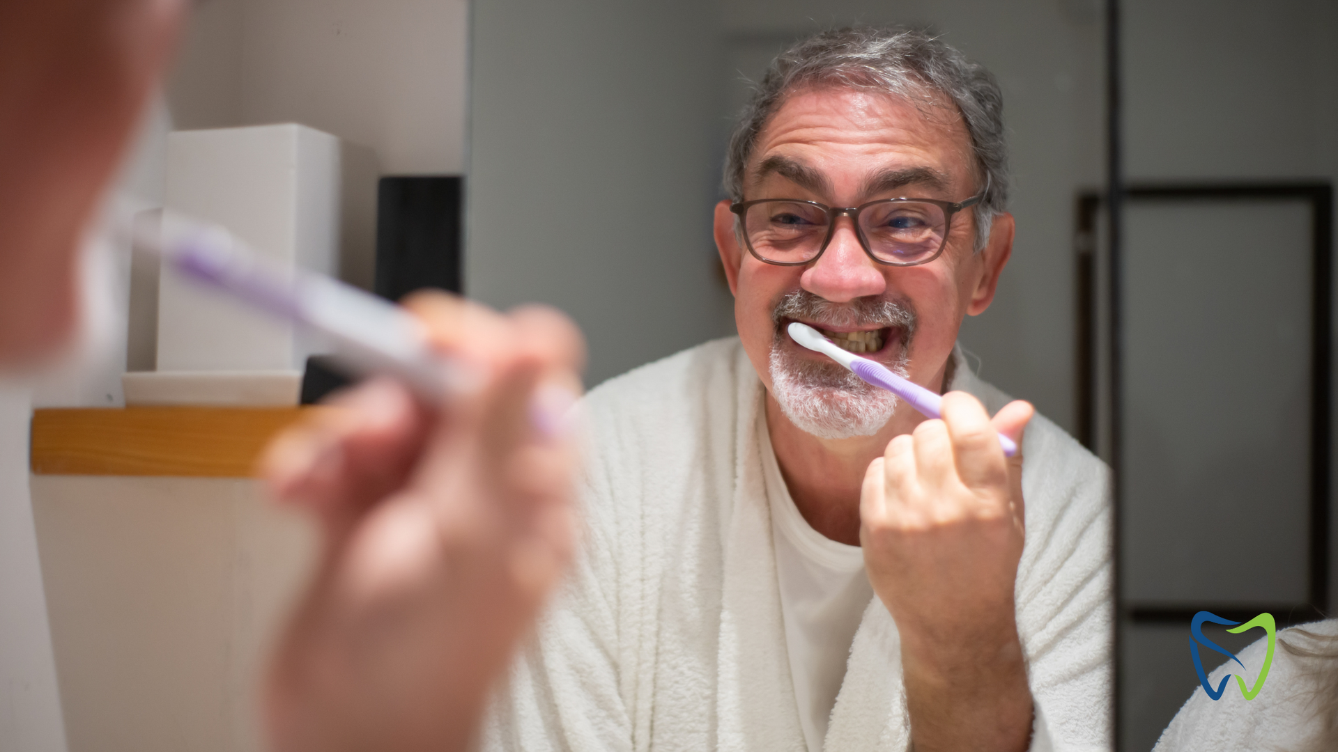 Man brushing teeth while looking in mirror, holding a toothbrush and toothpaste tube.