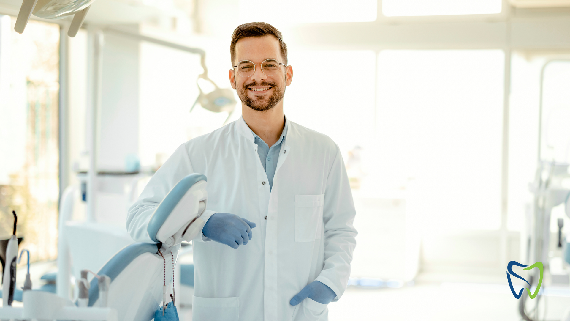 A dentist is standing in front of a dental chair in a dental office.