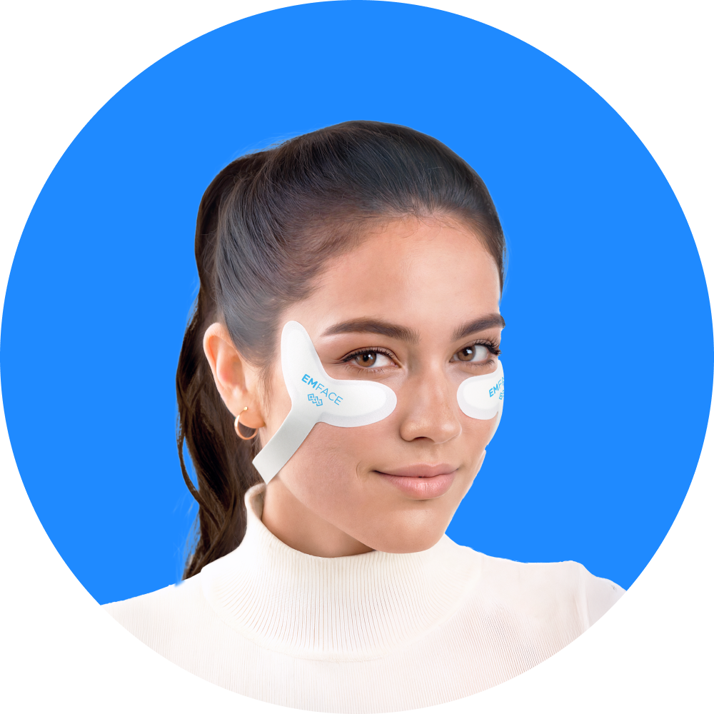 Woman wearing under-eye gel patches on a blue background
