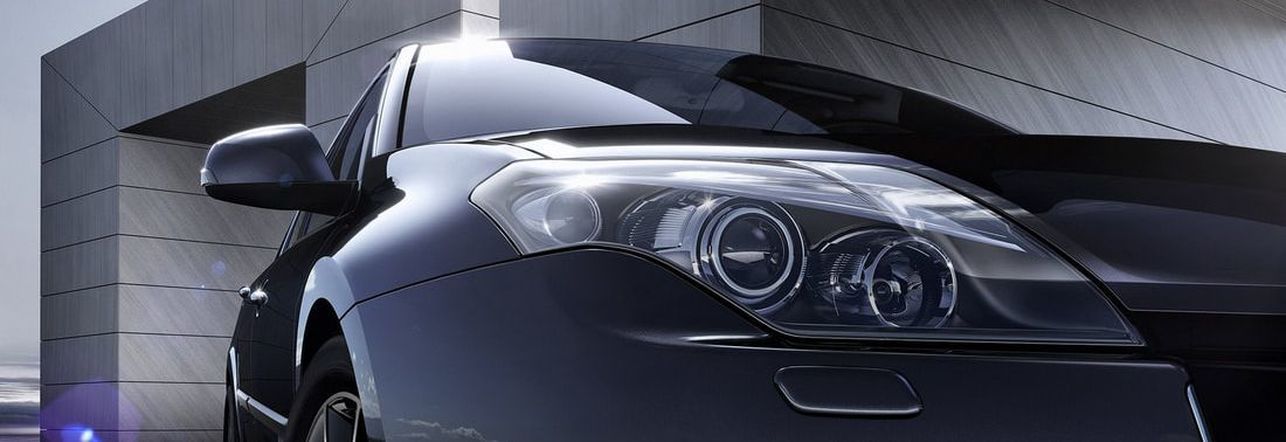 Black car in front of a modern building with a light reflection on the hood | Good Honest Mechanic