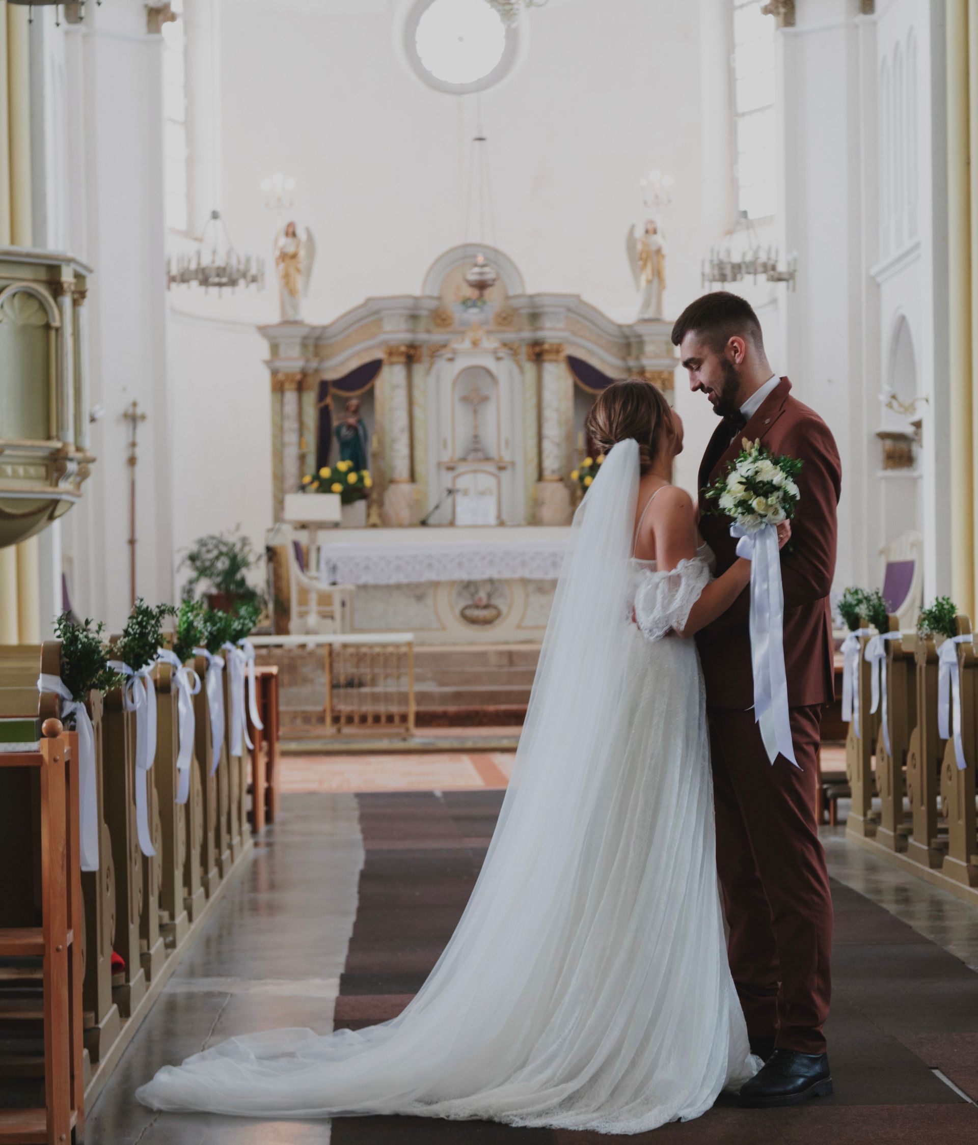 Bride and groom at the altar in a white church during their wedding ceremony