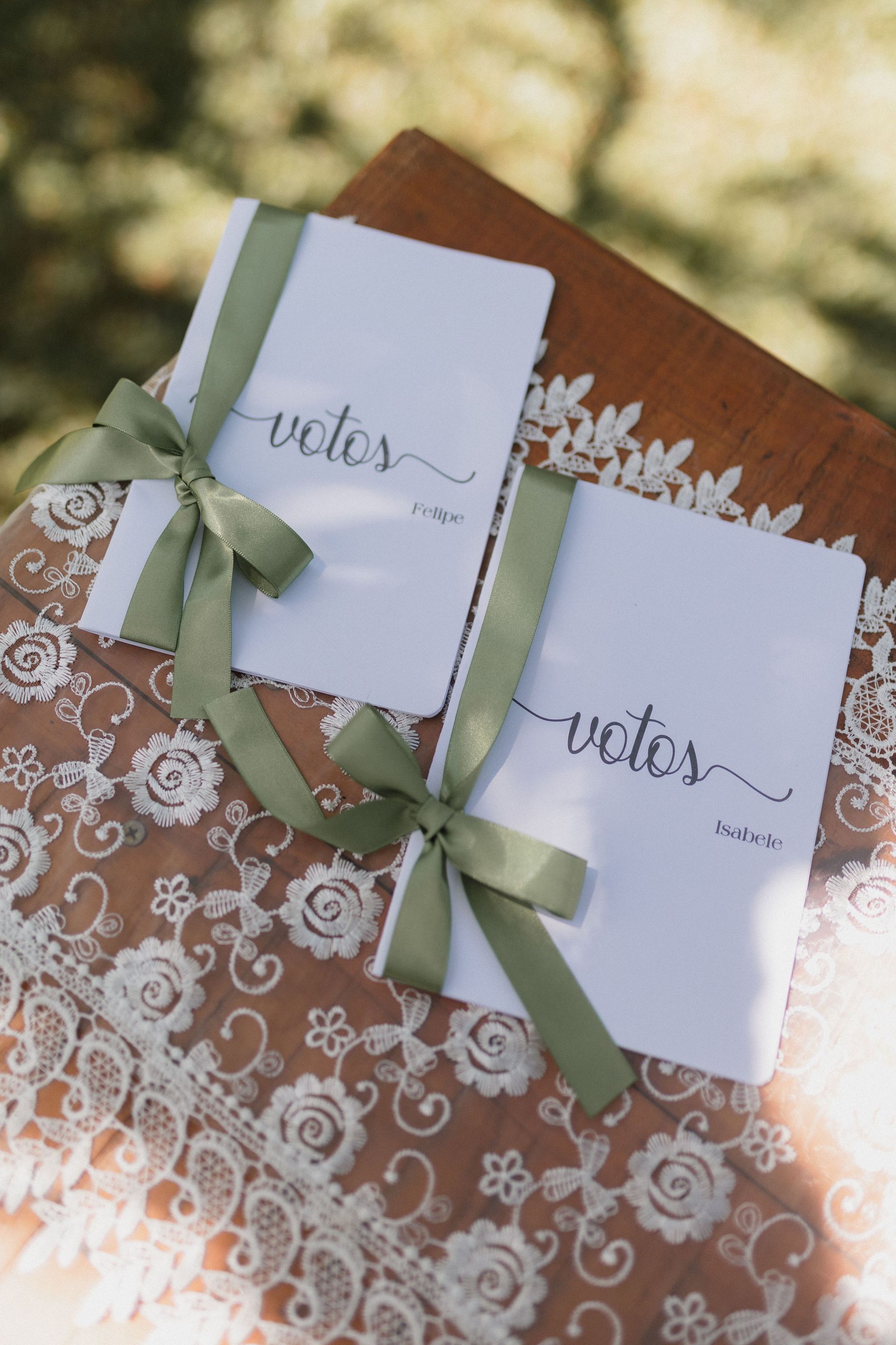 Two white cards with green ribbons on a lace-patterned brown envelope, labeled “vote”