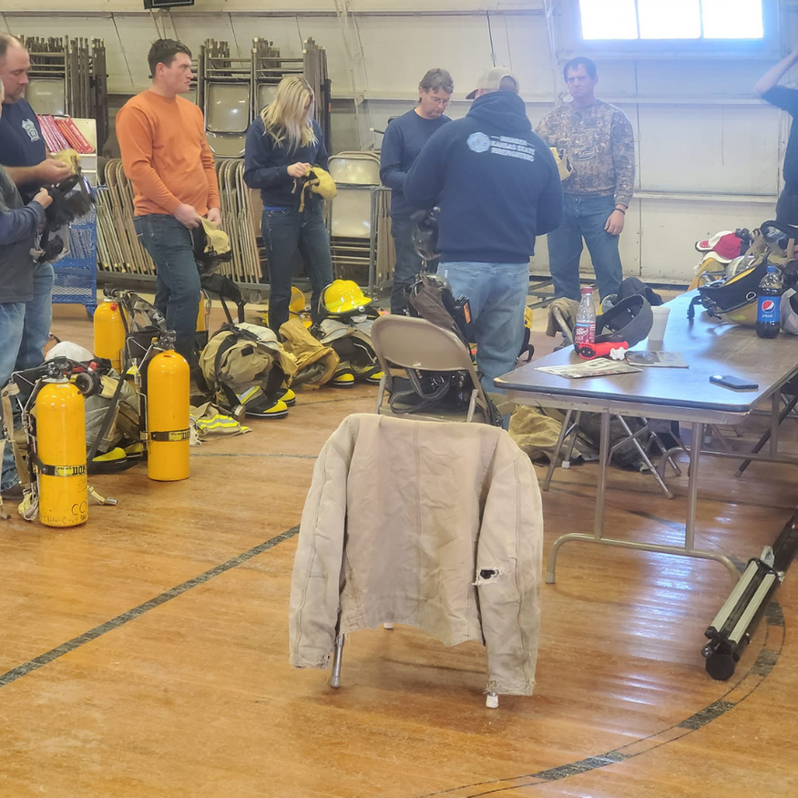 Firefighters in a training room with gear, preparing for a drill.