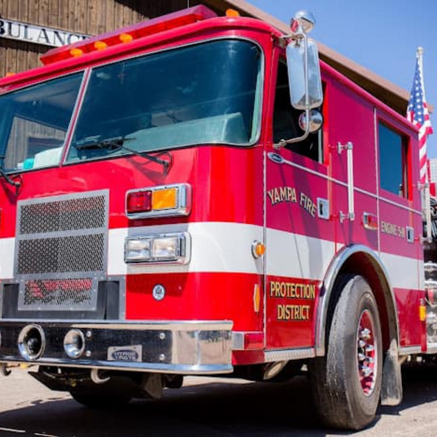 Red Santa Fe Fire Protection District fire truck parked on a city street, front view.