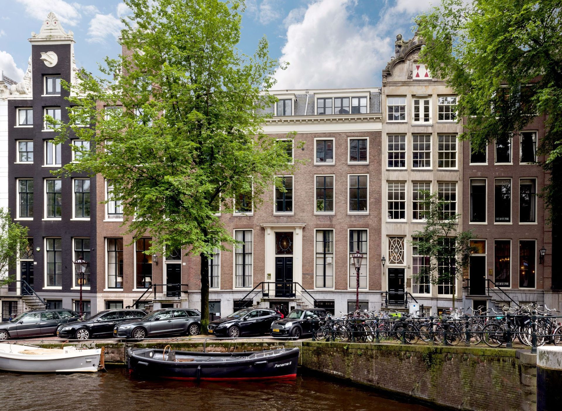 Een boot ligt aangemeerd voor een rij gebouwen