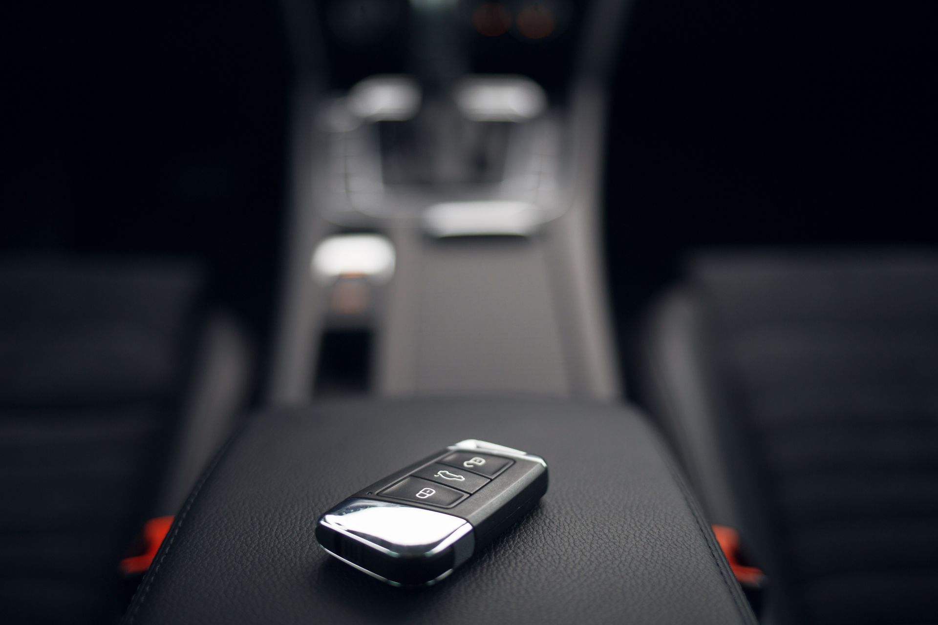 Car key fob on a car center console, with a blurred interior background