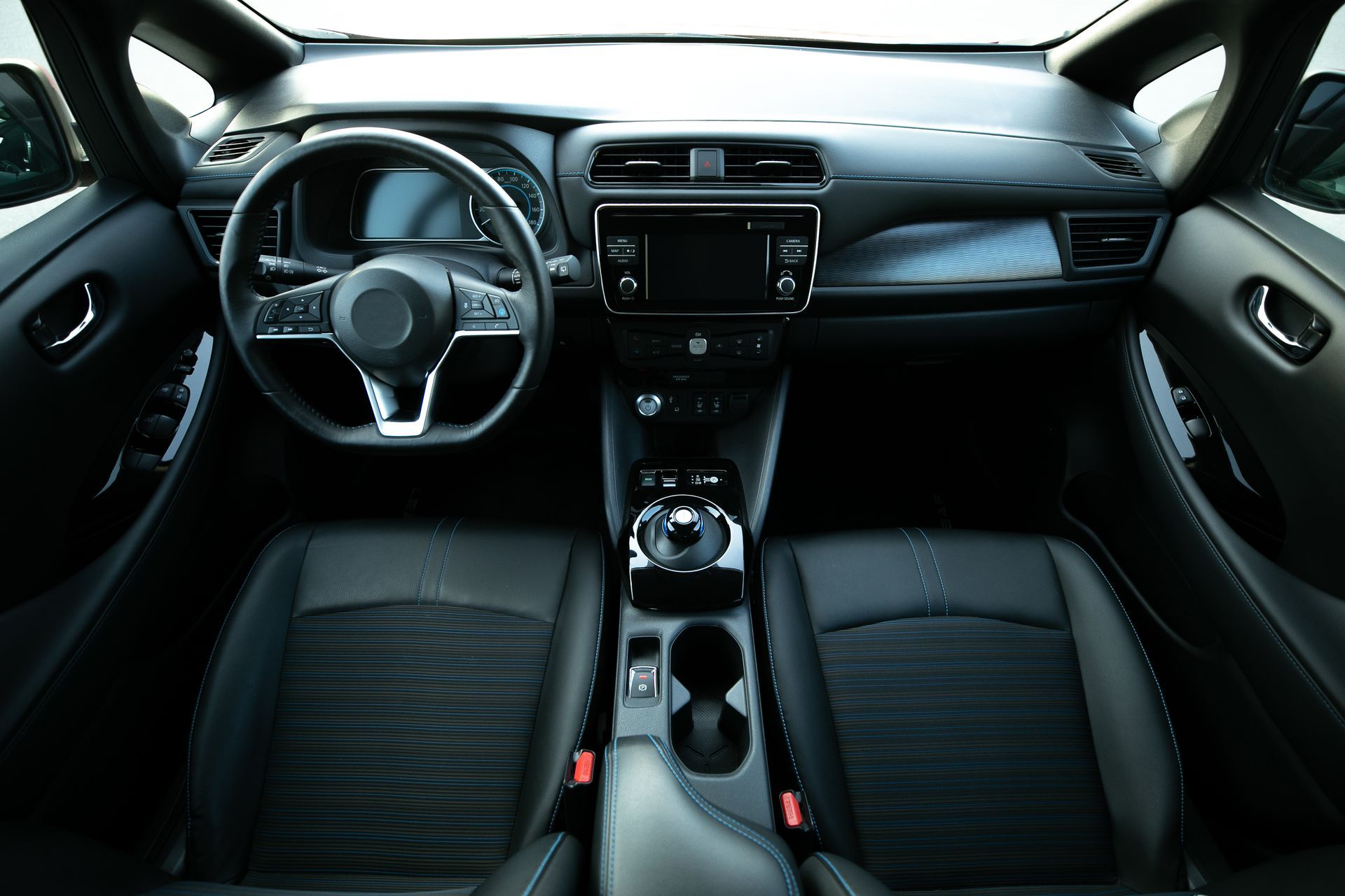 Wide-angle view of a modern car interior with black seats, steering wheel, dashboard, and center console Wide-angle view of a modern car interior with black seats, steering wheel, dashboard, and center console