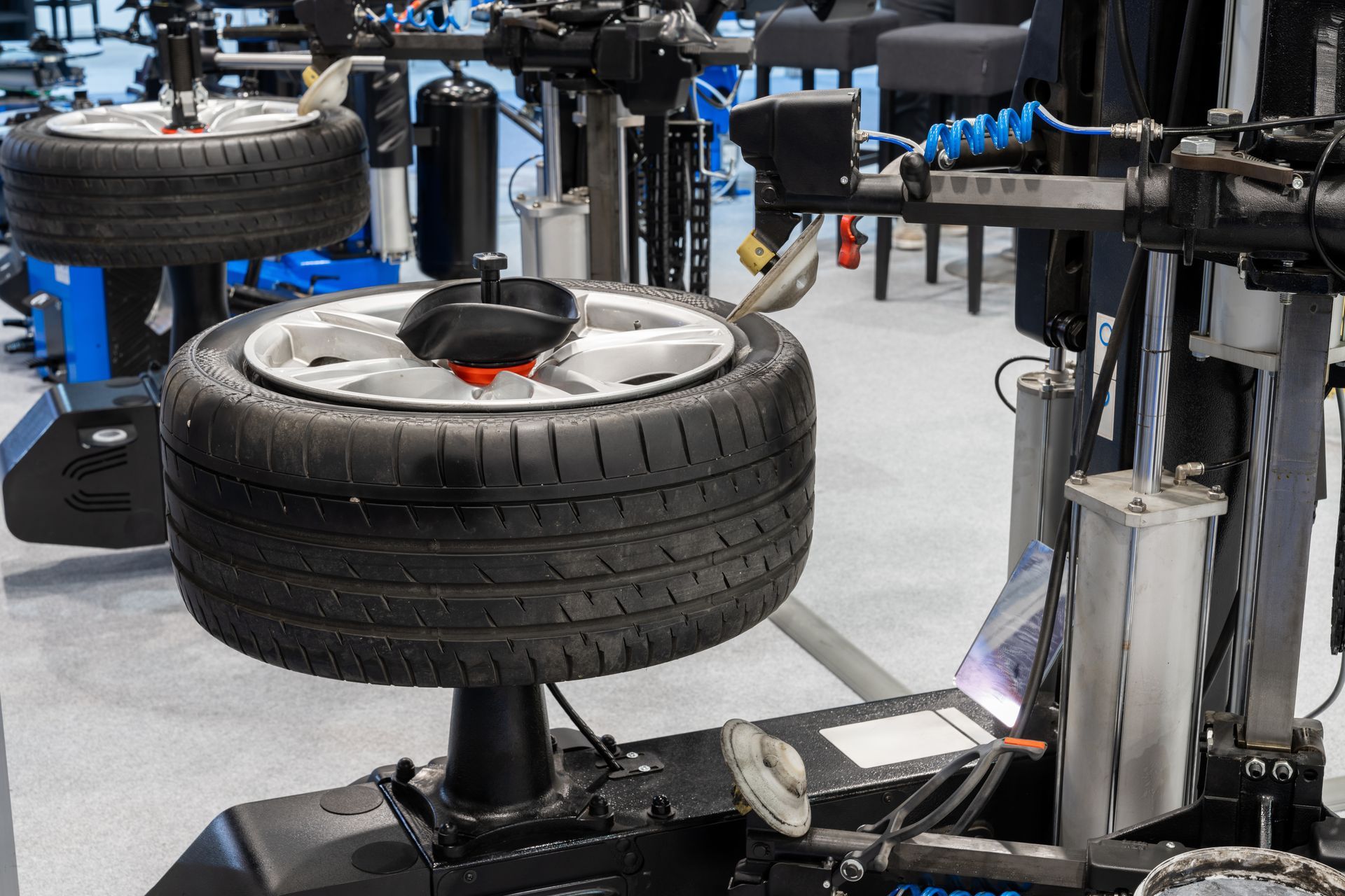 Auto repair machine lifting a car tire in a workshop