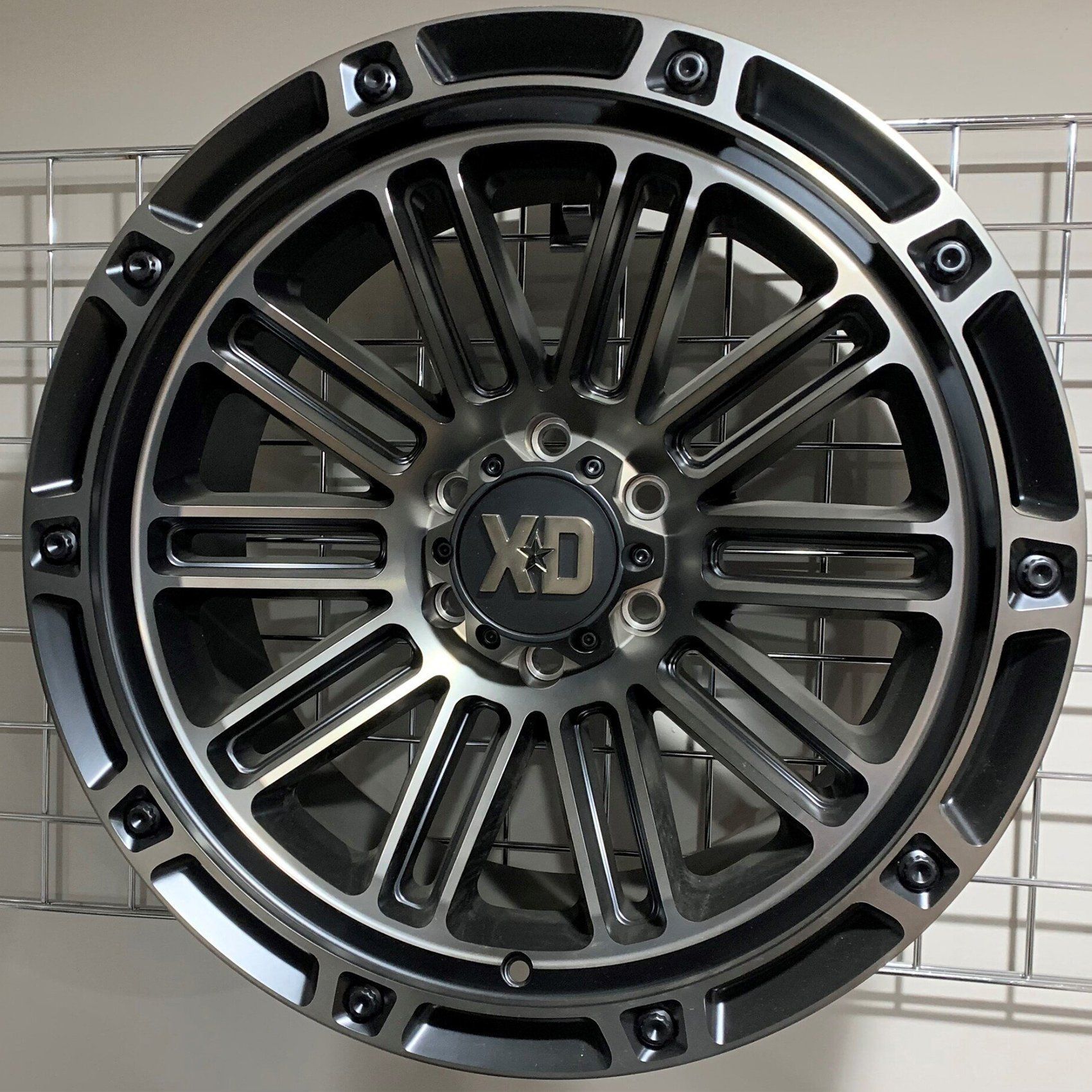 Black XD off-road truck wheel rim with silver accents on a light background