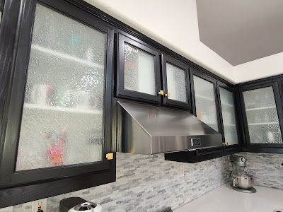 A kitchen with black cabinets and stainless steel appliances.