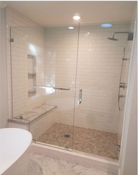 A bathroom with a walk in shower with a glass door.