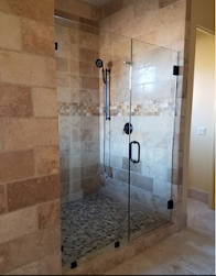 A bathroom with a walk in shower with a glass door