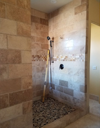A bathroom with a walk in shower and a ladder