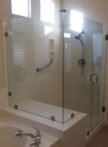 A bathroom with a tub and a shower with a glass door