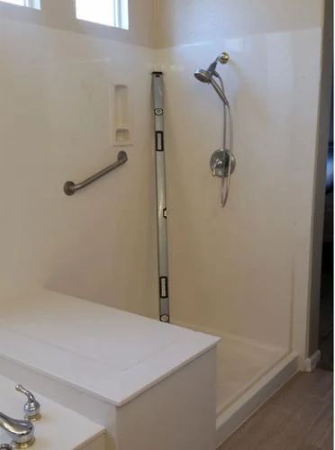 A bathroom with a shower and a yellow level