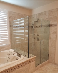 A bathroom with a tub and a shower with a glass door