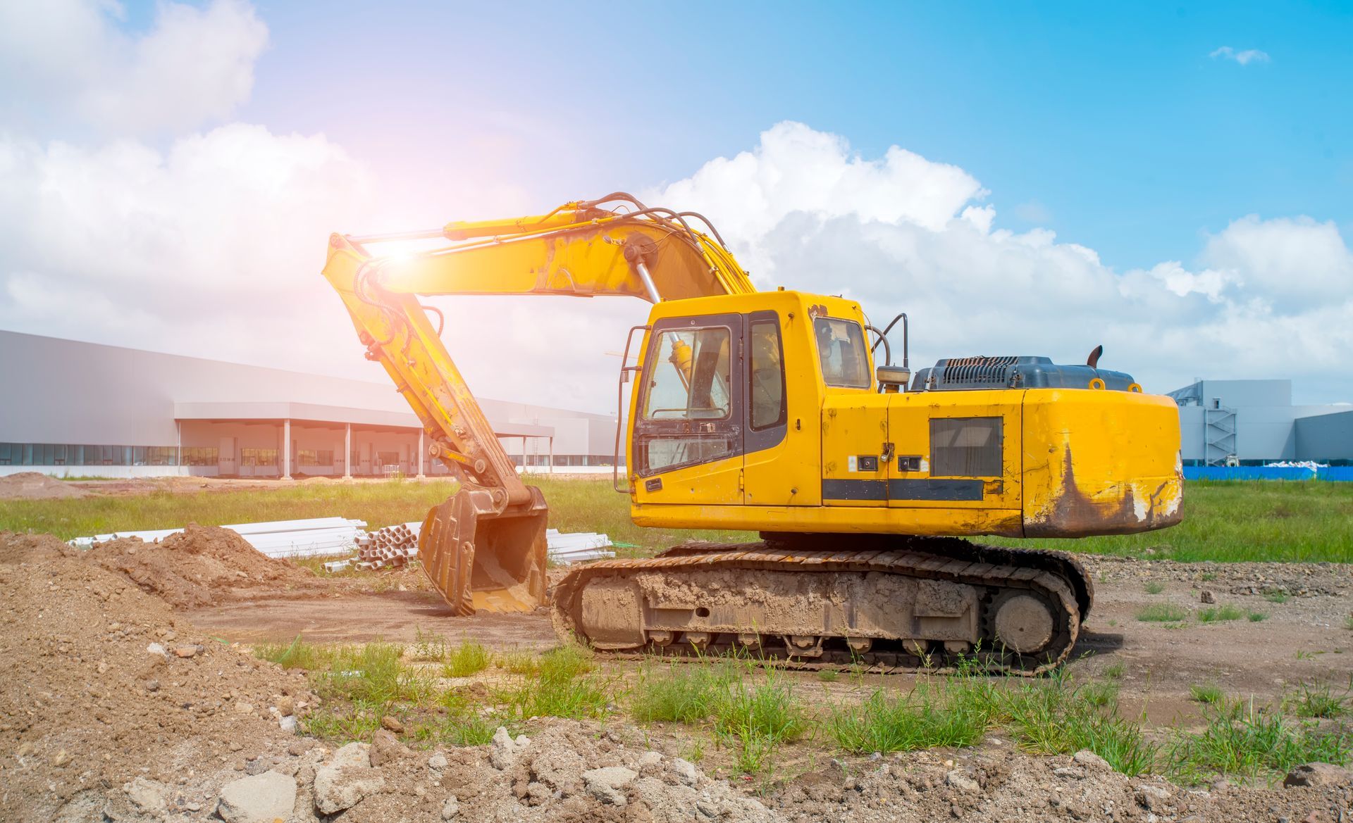 A yellow excavator is working on a construction site.