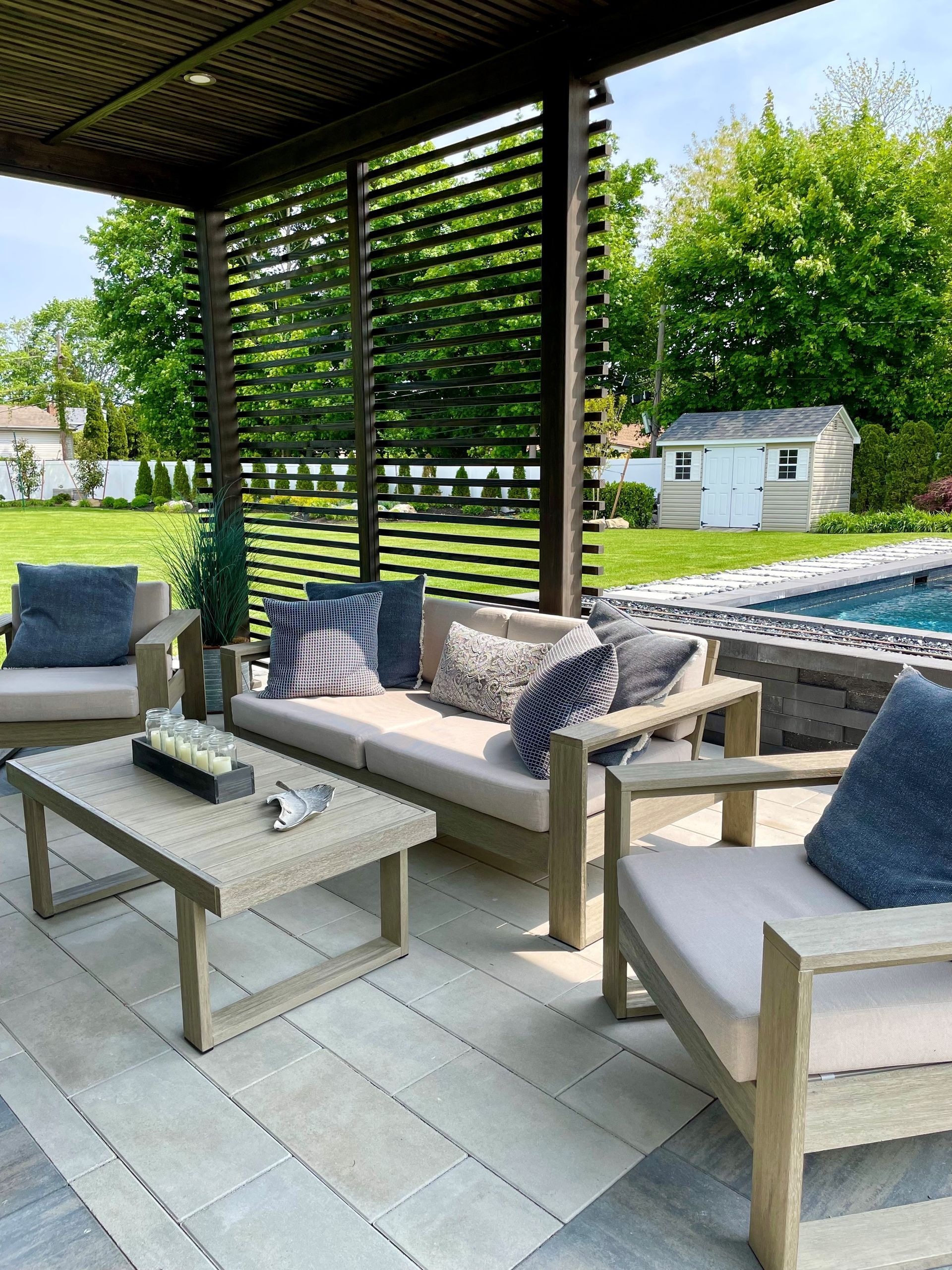 A patio with a couch , chairs , and a coffee table.