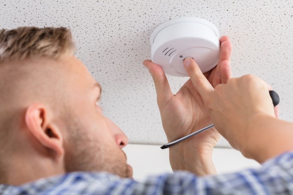 Technician is installing fire alarm