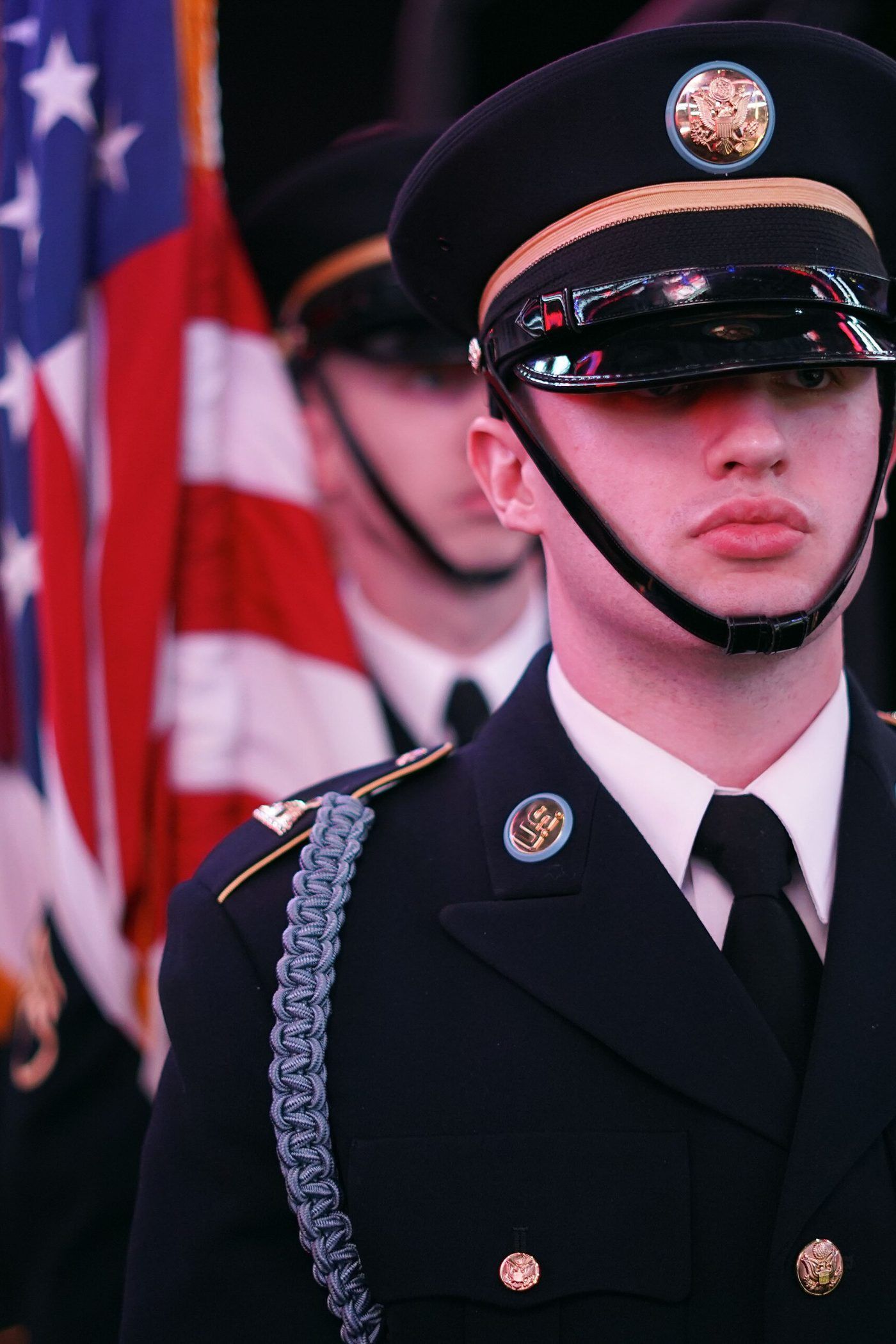 A United States honor guard member in dress cap carrying the colors