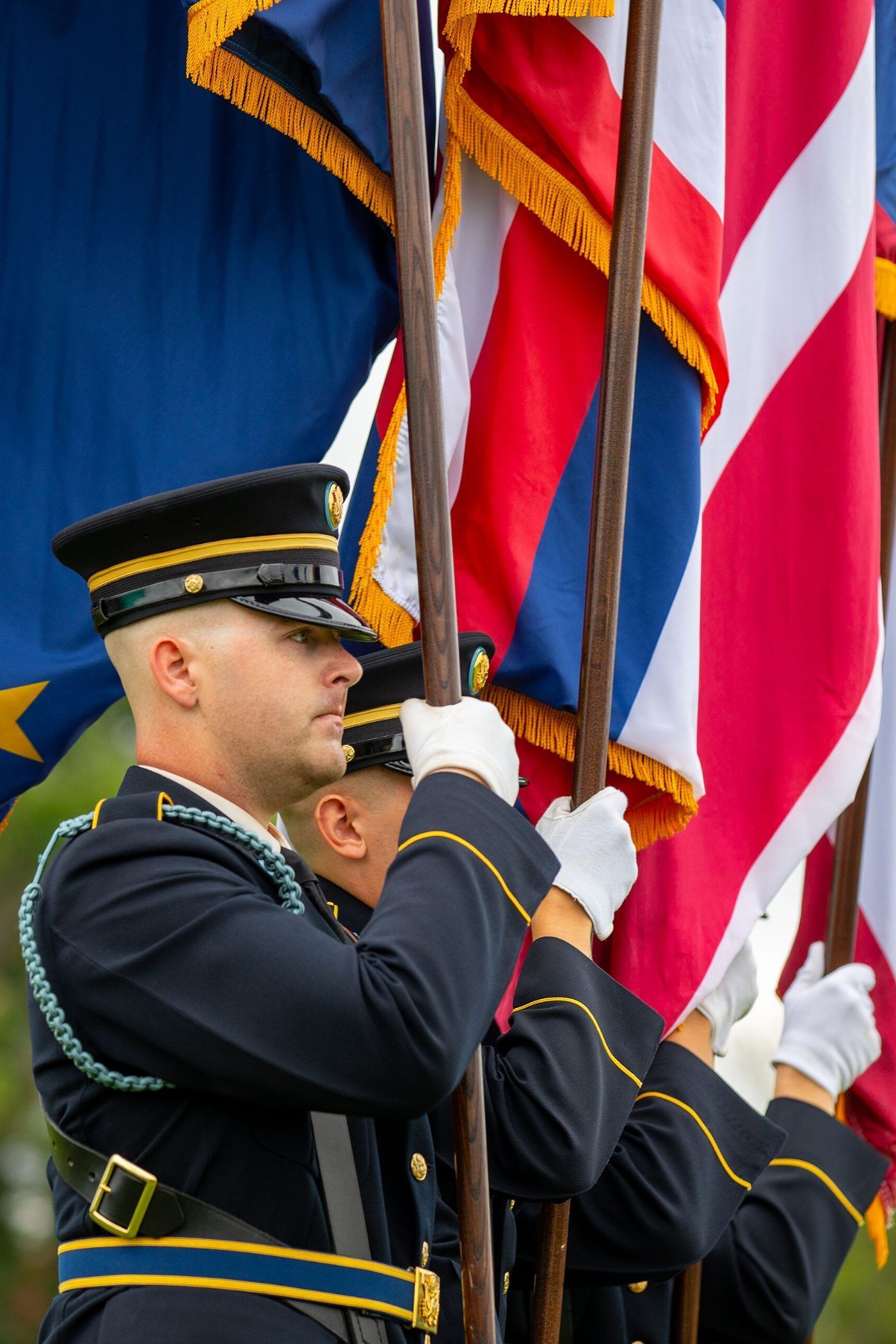 A United States Army soldier steadying the national colors and unit standards at a ceremony