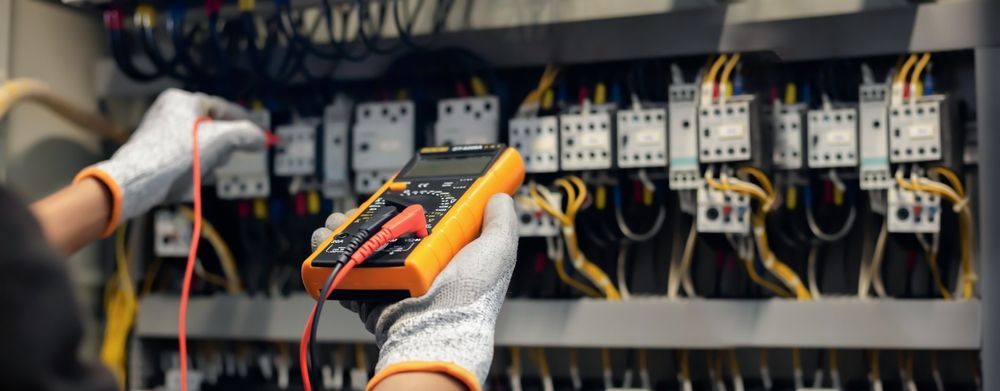 A person is using a multimeter to test a circuit board.