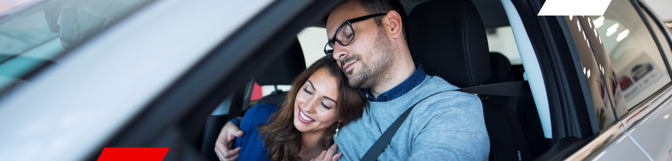 Um homem e uma mulher estão sentados em um carro.