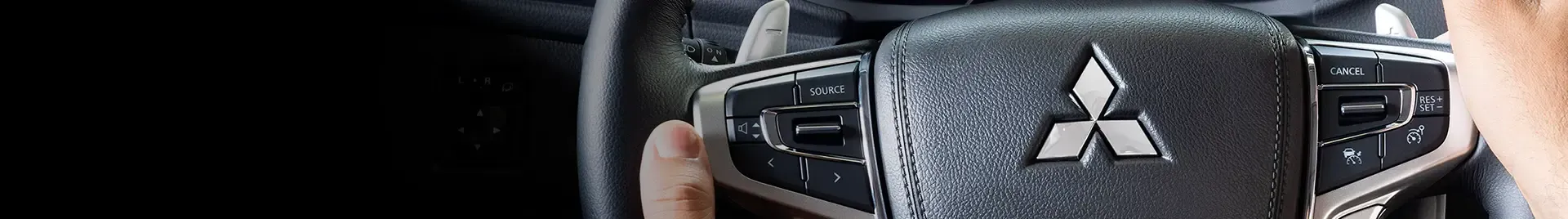 Um close de um volante com o logotipo da mitsubishi.