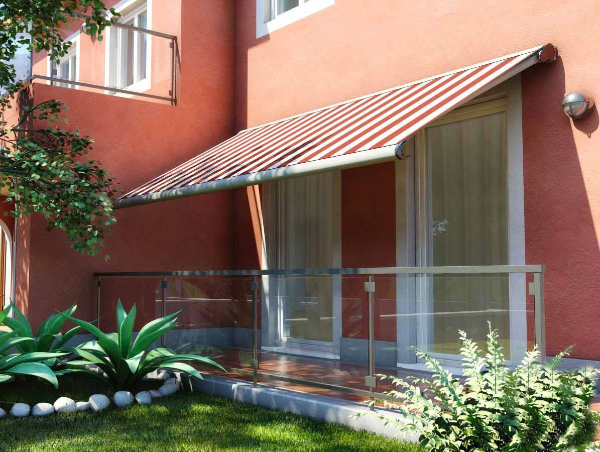 Esterno di un edificio con una tenda da sole in tegole rosse sopra le porte in vetro e una ringhiera in vetro.