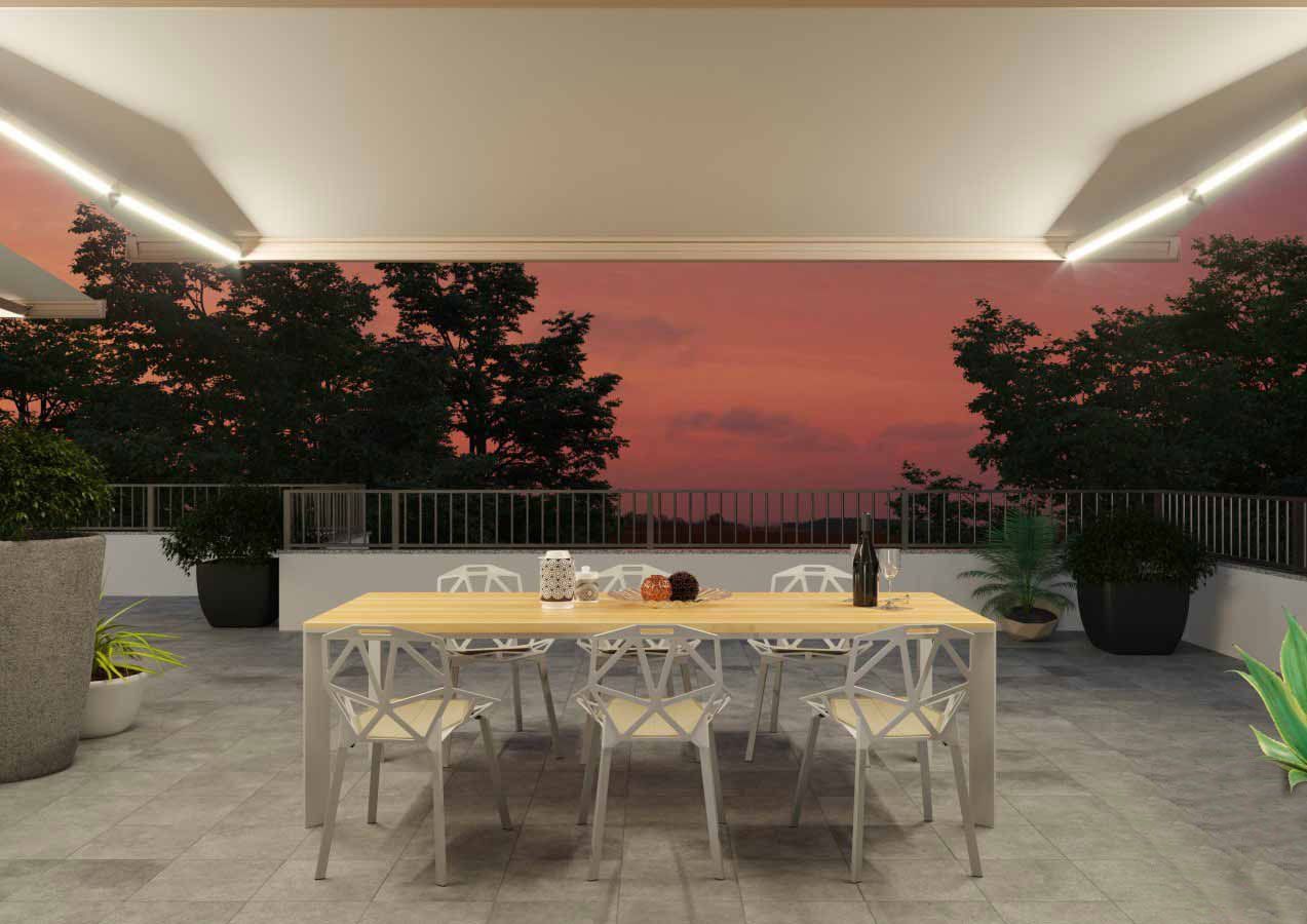 Tavolo da pranzo all'aperto apparecchiato per un pasto al tramonto, con sedie, piante e vista sugli alberi.