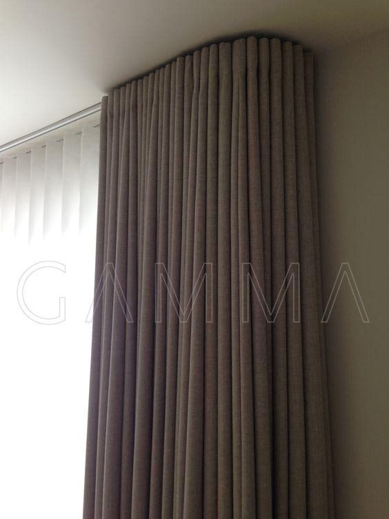 Tenda a pannello beige che va dal soffitto al pavimento e copre una finestra.