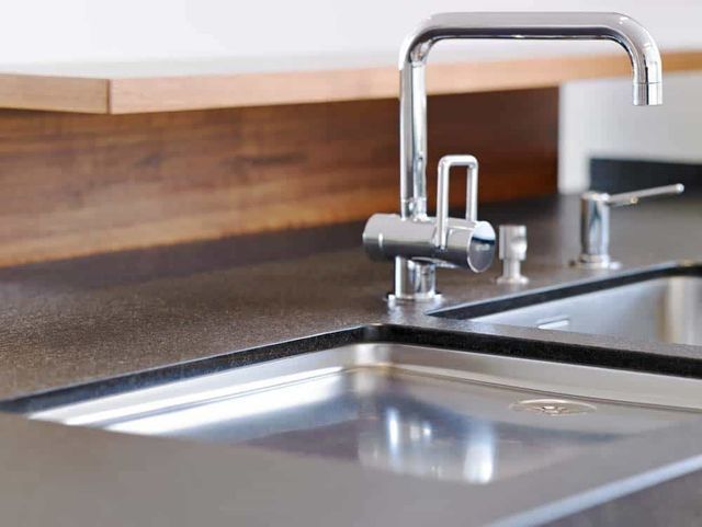 Moderne Küchenspüle mit Chromarmatur und Arbeitsplatte aus Holz