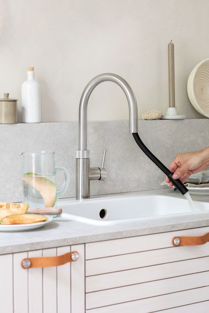 Brausekopf eines Wasserhahns über einem weißen Küchenspülbecken