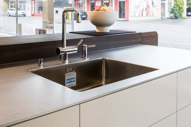 Moderne Küchenspüle mit Edelstahlbecken und Armatur in einem hellen Innenraum