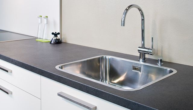 Moderne Küchenarbeitsplatte mit Edelstahlspüle und Chromarmatur
