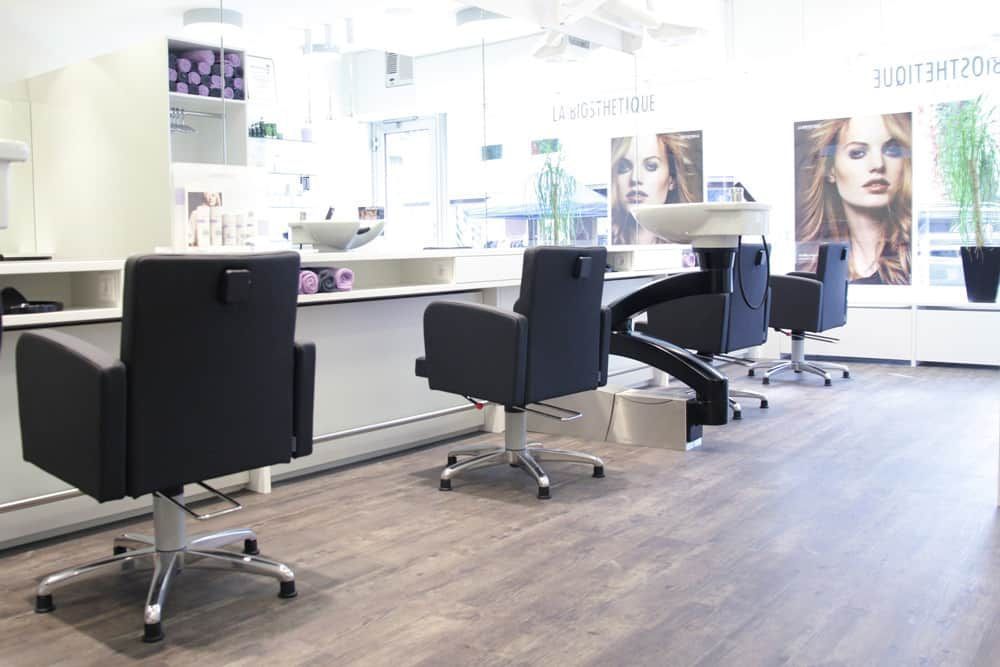 Modernes Saloninterieur mit Friseurstühlen, Spiegeln und Produktpräsentationen