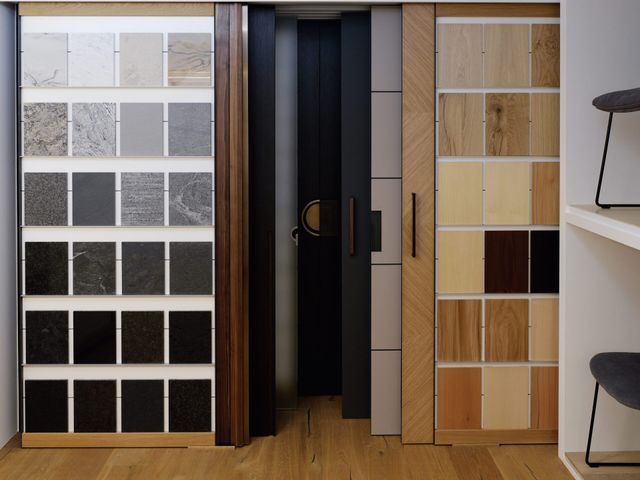 Ausstellung von Innentüren und Schiebepaneelen in einem Showroom mit Holz- und Glasoberflächen.