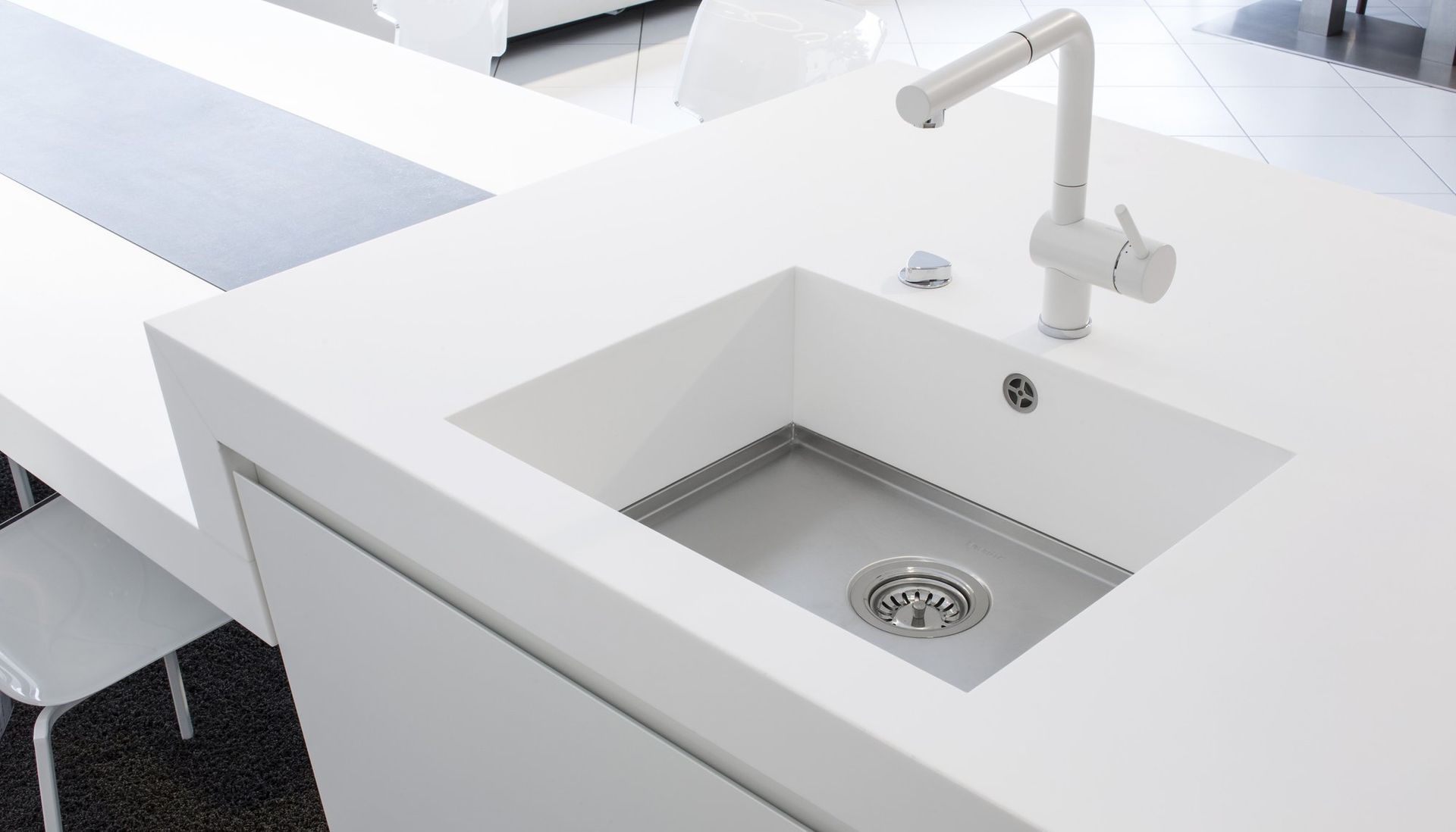 Moderne weiße Küchenspüle mit Armatur auf einer sauberen Arbeitsplatte