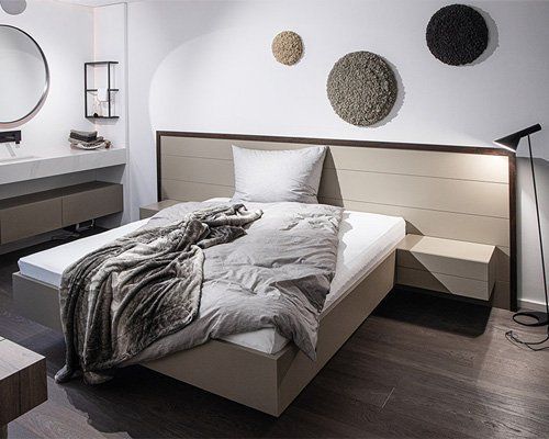 Modernes graues Schlafzimmer mit Bett, Kissen, strukturierter Wanddekoration und Stehlampe