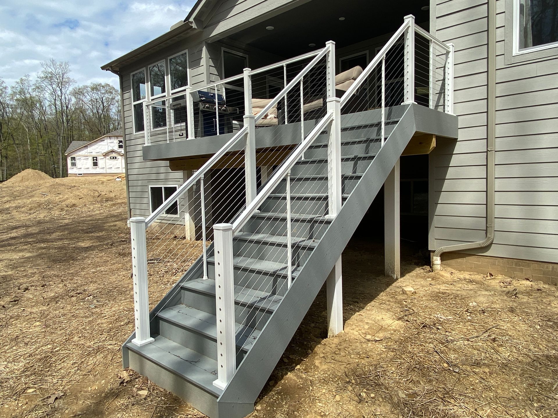 Outdoor wooden accessibility ramp with railings leading to a house porch