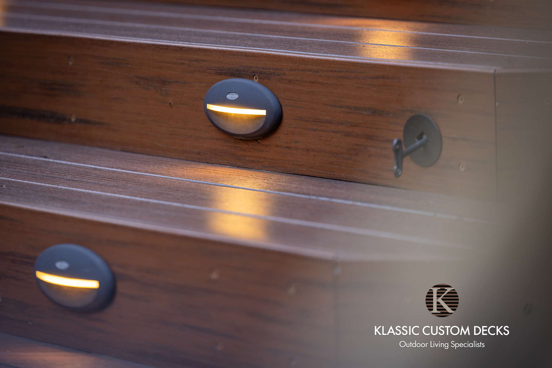 Dark wood furniture drawer front with round black knobs and a small keyhole detail