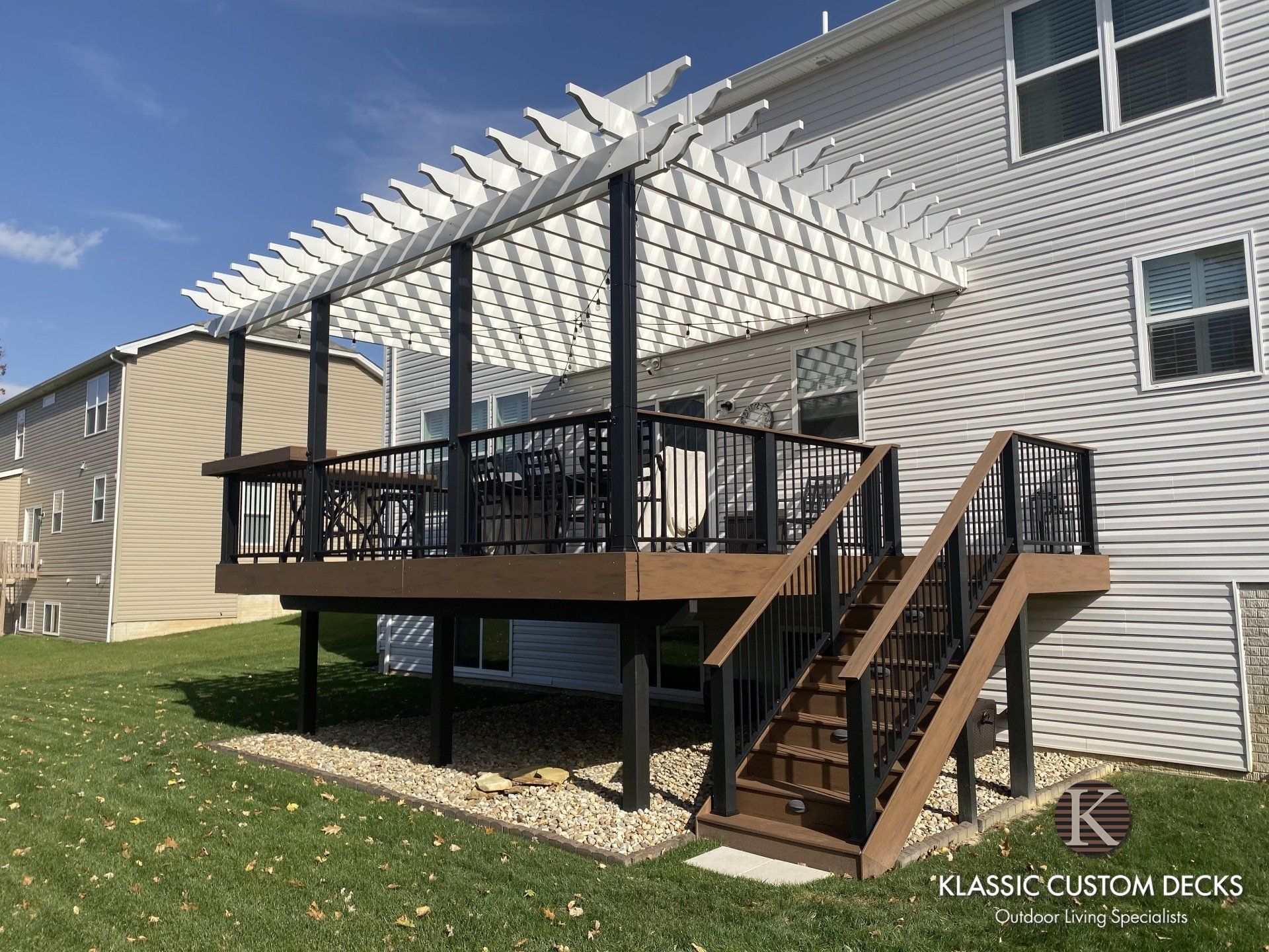 Back deck with stairs, pergola and railing on a beige apartment building